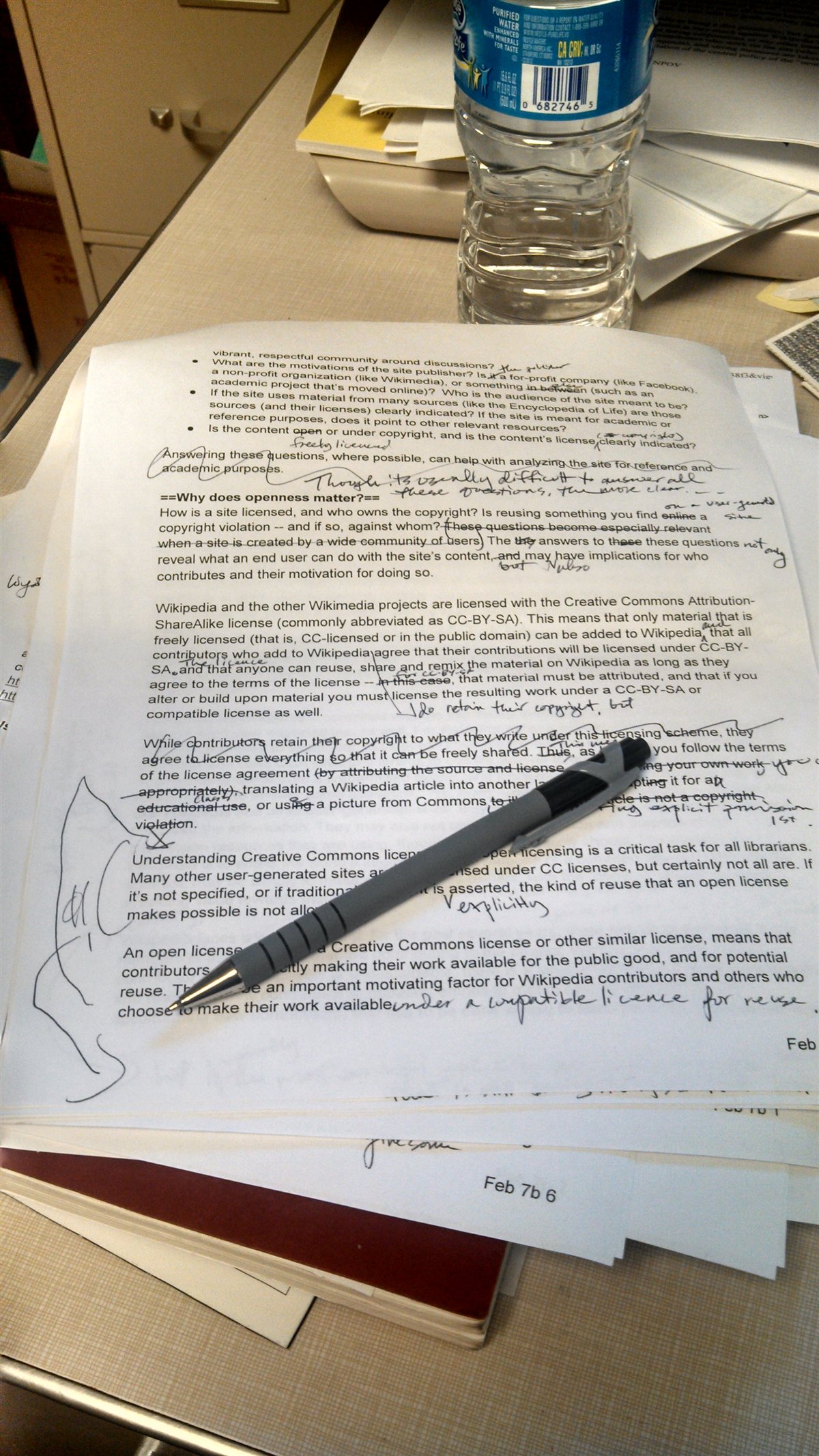 Copyedited manuscript with handwritten marks and a pen